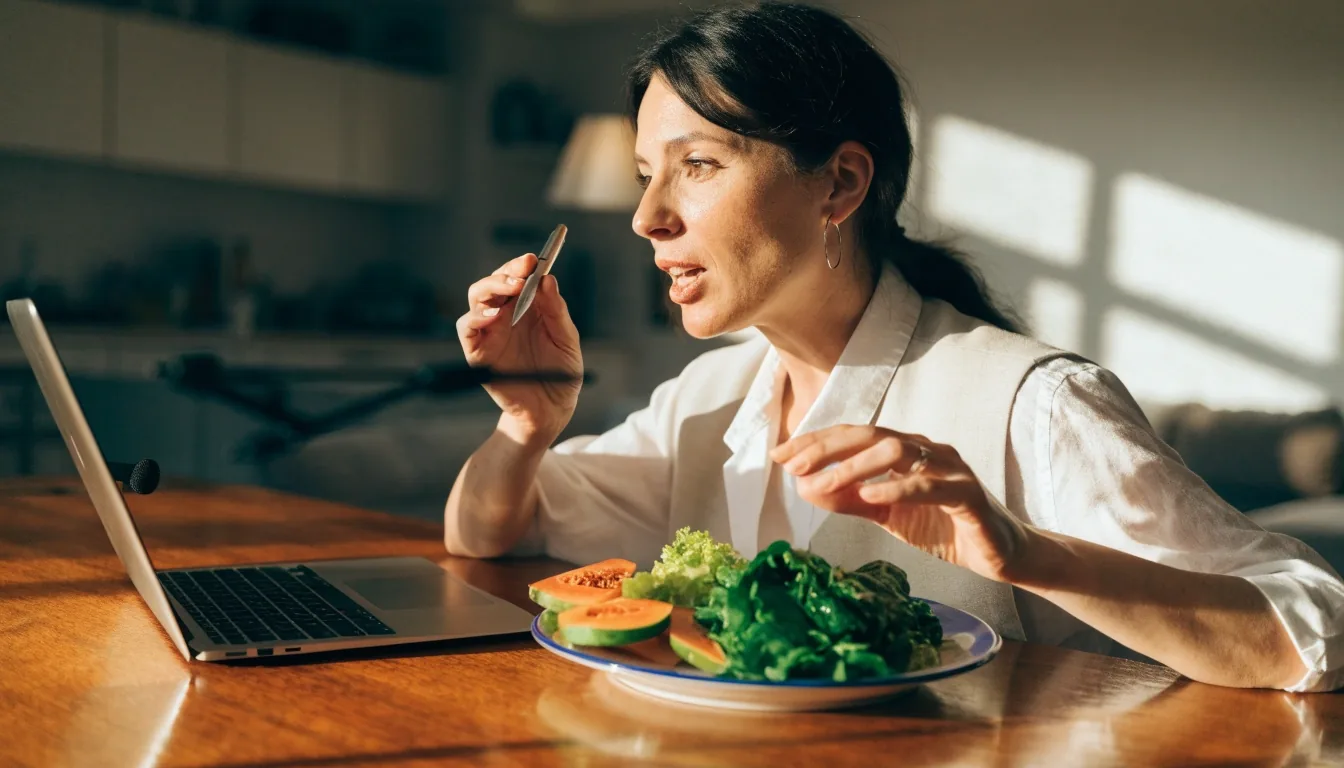 A registered dietitian speaking during an online nutrition consultation from a sunlit room with fresh vegetables nearby